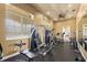Well-equipped home gym with rubber flooring, windows, ceiling fan, and fitness machines at 2125 Shackley Pl, Apopka, FL 32703