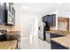 Modern kitchen featuring dark cabinets, granite countertops, and stainless steel appliances at 2125 Shackley Pl, Apopka, FL 32703