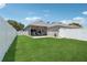 Spacious backyard with green lawn, white fence, and a covered patio area at 2215 Guiana Plum Dr, Orlando, FL 32828