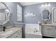 Bathroom featuring dual sinks, granite countertops, a tub, and vintage mirrors at 2215 Guiana Plum Dr, Orlando, FL 32828