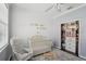 Bright Bedroom featuring wood paneled wall, crib, and comfortable rocking chair at 2215 Guiana Plum Dr, Orlando, FL 32828