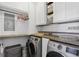 Well-organized laundry room with white cabinets, wood countertop, and modern washer/dryer at 2215 Guiana Plum Dr, Orlando, FL 32828