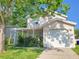 Charming two-story home featuring a covered porch, garage, and mature trees at 2320 Pebble Brook Rd, Kissimmee, FL 34741