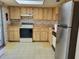 Functional kitchen with wood cabinets and standard appliances at 2320 Pebble Brook Rd, Kissimmee, FL 34741