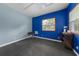 Spacious bonus room with blue walls, window, and dark floors for exercise or storage at 2326 Florida Ave, Oviedo, FL 32765