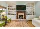 Cozy living room featuring a brick fireplace, built-in shelving, and natural light at 2326 Florida Ave, Oviedo, FL 32765