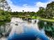 Picturesque lake view featuring a fountain, covered dock, and lush greenery, creating a serene waterfront scene at 2326 Florida Ave, Oviedo, FL 32765