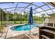 Inviting screened-in pool with attached spa and umbrella for shade on the outdoor patio at 2326 Florida Ave, Oviedo, FL 32765