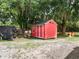 A small red storage shed sits on a grassy lawn next to grazing donkeys at 2326 Florida Ave, Oviedo, FL 32765