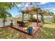 Beautiful backyard features an outdoor dining and lounge area under a pergola with climbing flowers at 2349 Plantation Oak Dr, Orlando, FL 32824