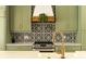Close up of modern kitchen with stainless steel stove and custom backsplash at 2349 Plantation Oak Dr, Orlando, FL 32824