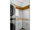 Functional laundry space offers modern stacked washer and dryer with white cabinets and wood counters at 2349 Plantation Oak Dr, Orlando, FL 32824