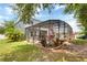 A view of a home's screened-in pool and backyard with mature landscaping at 2349 Plantation Oak Dr, Orlando, FL 32824