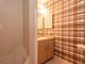 Bathroom with a standard shower/tub combination and vintage style sink with cabinetry and plaid wallpaper at 2361 Kimberly Dr, Deltona, FL 32738