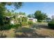 An eye-level front exterior showing a white house, manicured shrubs and mature trees at 2361 Kimberly Dr, Deltona, FL 32738