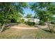 A circular walkway leading up to a white home with brick details, lush greenery and mature trees at 2361 Kimberly Dr, Deltona, FL 32738
