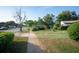 Residential street view showcases the home's front yard with established landscaping and green painted driveway at 2361 Kimberly Dr, Deltona, FL 32738