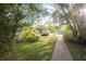 A well-maintained front yard features lush greenery, a paved walkway, and mature trees at 2361 Kimberly Dr, Deltona, FL 32738