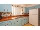 Charming kitchen featuring blue cabinets, orange countertops, double sink, and a vintage refrigerator at 2361 Kimberly Dr, Deltona, FL 32738