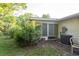 Outdoor patio area featuring a screened-in porch, chair, AC Unit, and lush landscaping at 2361 Kimberly Dr, Deltona, FL 32738