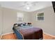 Cozy bedroom featuring hardwood floors, a ceiling fan, and natural light from the windows at 2409 Garbelia Ave, Orlando, FL 32817