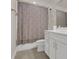 Bathroom featuring white cabinets, tile flooring, and shower with patterned curtain at 2449 Southlawn Ln, Clermont, FL 34714