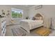 Bright bedroom with a decorative rug, large window with wooded view, and decorative plants at 2449 Southlawn Ln, Clermont, FL 34714