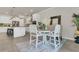 Bright dining area flows into kitchen, featuring white chairs and a white marble-topped table on a furry rug at 2449 Southlawn Ln, Clermont, FL 34714
