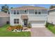Charming two-story home with a well-maintained lawn and a two-car garage at 2449 Southlawn Ln, Clermont, FL 34714