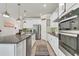 Well-equipped kitchen featuring a granite island, stainless steel appliances, and stylish pendant lighting at 2449 Southlawn Ln, Clermont, FL 34714