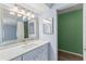 Bathroom featuring a light blue vanity with white countertop and a decorative mirror at 2486 Citrus Club Ln # 408, Orlando, FL 32839