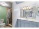 Updated bathroom with walk-in shower, a vanity with bright blue cabinets and a decorative mirror at 2486 Citrus Club Ln # 408, Orlando, FL 32839