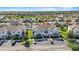 Aerial view of a light-blue townhome community with parking spaces and a lake in the distance at 281 Primrose Dr, Davenport, FL 33837
