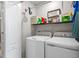 Well-organized laundry room featuring a washer, dryer, storage shelf, and a crisp, clean ambiance at 281 Primrose Dr, Davenport, FL 33837