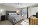 Cozy bedroom with a gray upholstered bed, neutral walls, and natural light at 281 Primrose Dr, Davenport, FL 33837