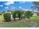 Backyard featuring green grass and landscaped garden beds with an arched opening at 3677 Serena Ln, Clermont, FL 34711