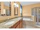 Bathroom featuring dual sinks, granite counters, soaking tub, and glass enclosed shower at 3677 Serena Ln, Clermont, FL 34711