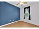 A blue bedroom featuring wood-look floors and a window with black curtains at 3677 Serena Ln, Clermont, FL 34711