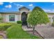 Inviting front entrance with arched doorway, manicured landscaping, and brick-paved driveway at 3677 Serena Ln, Clermont, FL 34711