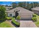 Charming single-story home with a manicured lawn, brick driveway, and two-car garage, offering curb appeal at 3677 Serena Ln, Clermont, FL 34711