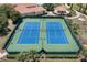 Aerial view of well-maintained community tennis courts surrounded by green landscaping and palm trees at 3677 Serena Ln, Clermont, FL 34711