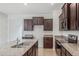 Bright kitchen with dark wood cabinets, granite countertops and stainless steel appliances at 3975 Kennebunk Loop, Mount Dora, FL 32757
