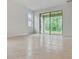 Minimalist living area with tile floors, large sliding glass door, and bright, neutral paint at 3975 Kennebunk Loop, Mount Dora, FL 32757