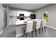 Modern kitchen features white cabinetry, black appliances, a center island with seating, and natural light from a window at 4537 Cross Prairie Pkwy, St Cloud, FL 34772
