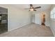 Cozy bedroom features carpeted floors, ceiling fan, closet, and ensuite bathroom access at 4816 Crow St, Orlando, FL 32819