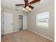Comfortable bedroom with ceiling fan, closet, window, and neutral wall paint at 4816 Crow St, Orlando, FL 32819