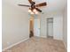 Cozy bedroom featuring a ceiling fan, neutral walls, plush carpet, and a closet for storage at 4816 Crow St, Orlando, FL 32819