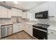 Updated kitchen featuring stainless appliances, white cabinetry and decorative backsplash at 4816 Crow St, Orlando, FL 32819