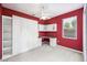 Bedroom features bright red walls, large built-in storage and desk, and a ceiling fan at 487 Foxhill Dr, Debary, FL 32713