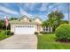 Charming home with a green tile roof, lush landscaping, and a spacious two-car garage at 487 Foxhill Dr, Debary, FL 32713